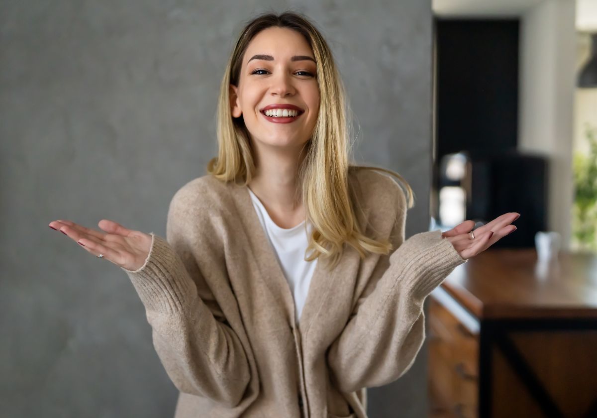 Mulher com as mãos para cima, como pose de indecisão