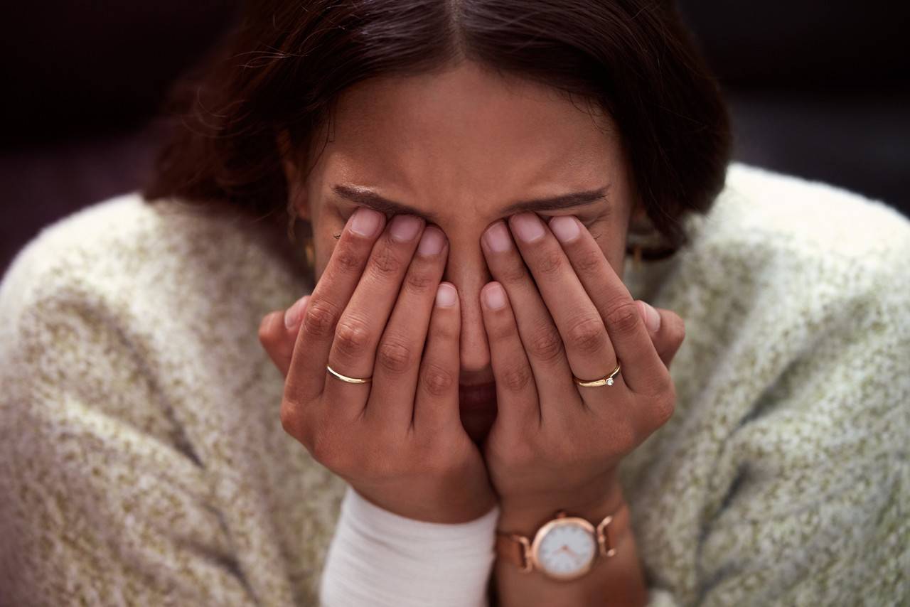 Mulher com a mão nos olhos